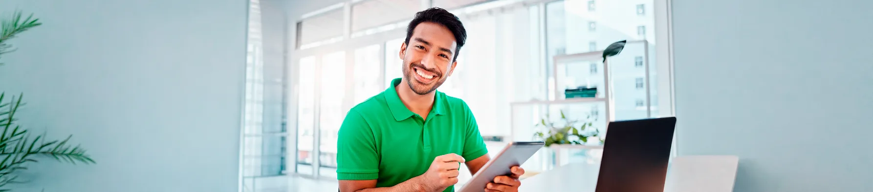 Consultor sorridente usa tablet em escritório, reforçando a facilidade da assinatura eletrônica com suporte em português para usuários.